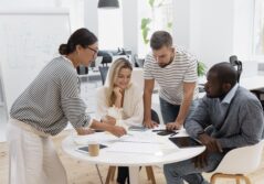 4 personnes autour d'une table en train de réfléchir