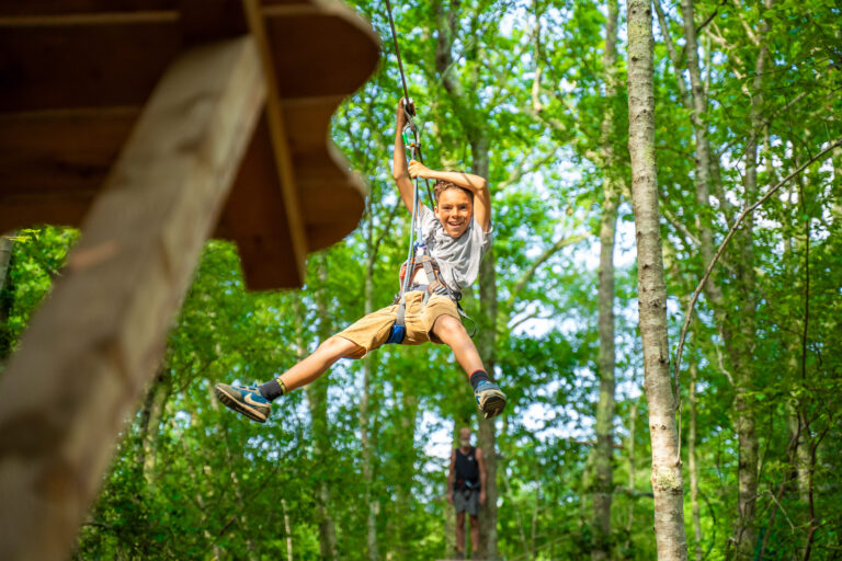 Garçon en l'air qui fait de l'accrobranche