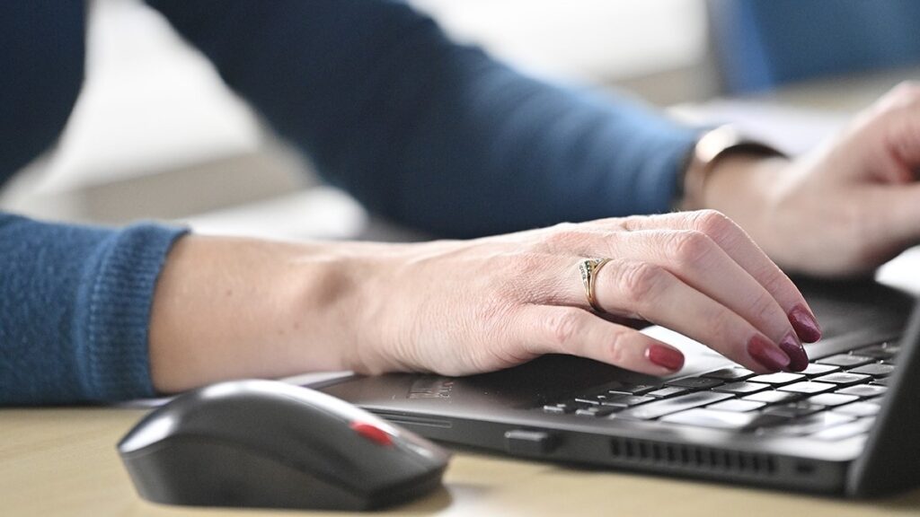 Des mains qui tapent sur un clavier d'ordinateur