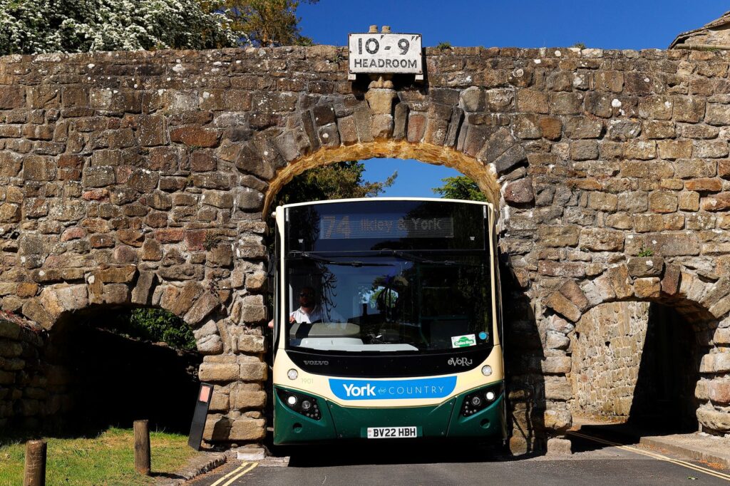 Transdev driver Wayne Moody calmly guides his bus through Yorkshire’s Bolton Abbey arch – just 9 ft 5 inches wide – as images of him completing the task without a scratch go viral on social media