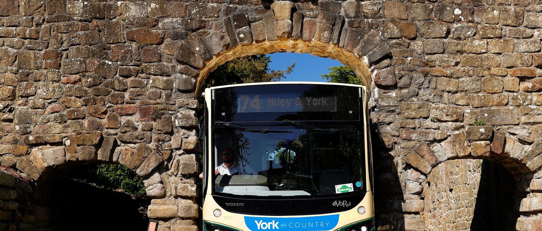 Transdev driver Wayne Moody calmly guides his bus through Yorkshire’s Bolton Abbey arch – just 9 ft 5 inches wide – as images of him completing the task without a scratch go viral on social media